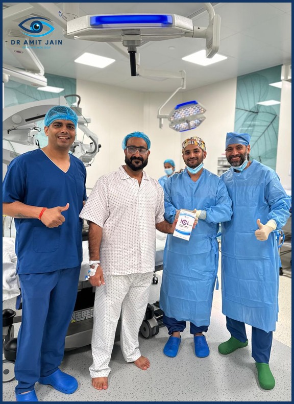 Dr. Amit Jain and two surgeons in scrubs with patient hold a book in an operating room in eye hospital Dubai