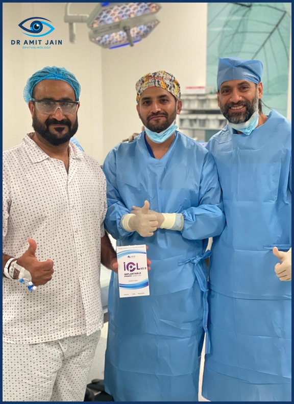 Dr. Amit Jain and one surgeon in scrubs with patient hold a book in an operating room in eye hospital Dubai